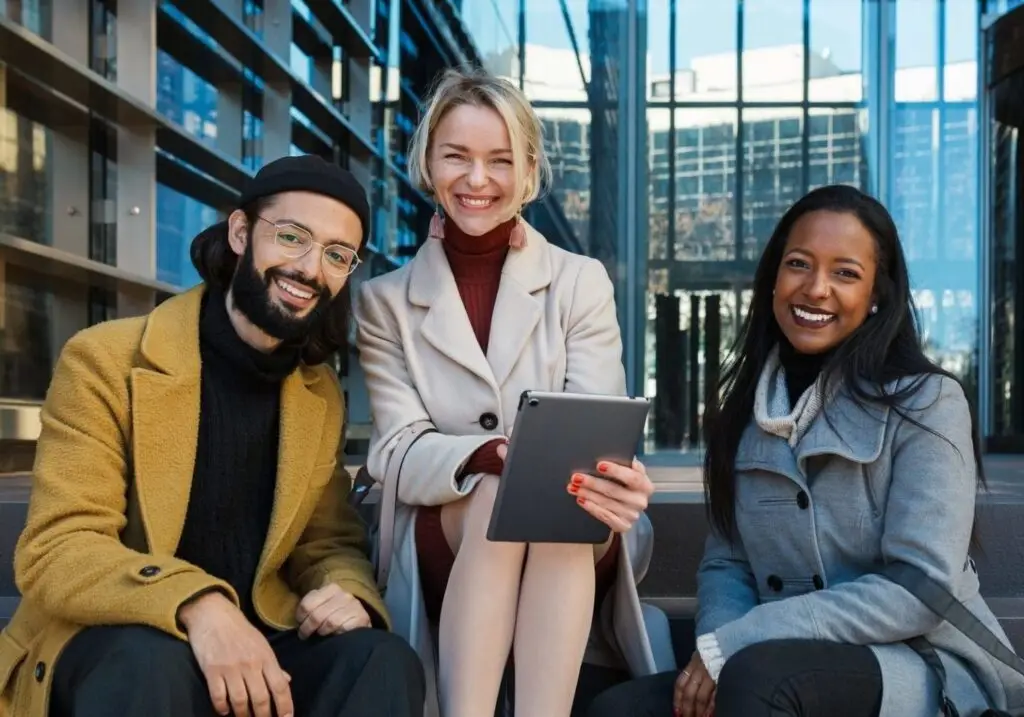 business-colleagues-looking-at-camera-and-smile-while-sitting-on-the-stairs-outside-the-office-e1656221977504.jpg